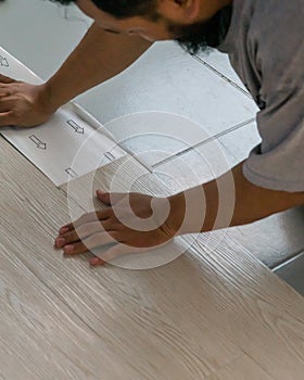 A man installing new vinyl tile floor, a DIY home project