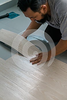 A man installing new vinyl tile floor, a DIY home project