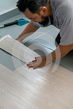 A man installing new vinyl tile floor, a DIY home project