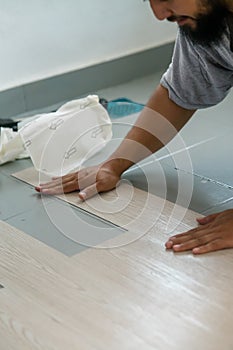 A man installing new vinyl tile floor, a DIY home project