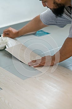 A man installing new vinyl tile floor, a DIY home project