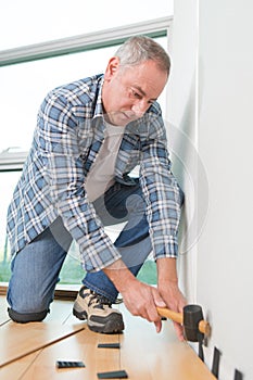 Man installing new wooden laminate flooring