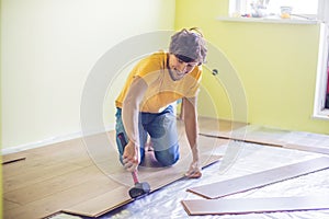 Man installing new wooden laminate flooring. infrared floor heat