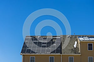 Man installing photovoltaic solar panels alternative energy on roof