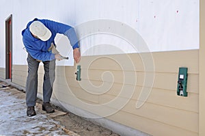 Man installing siding using gauges photo