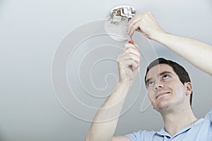 Man Installing Smoke Or Carbon Monoxide Detector