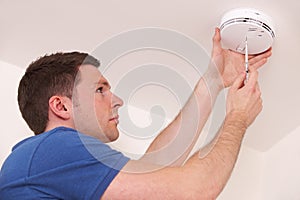 Man Installing Smoke Or Carbon Monoxide Detector