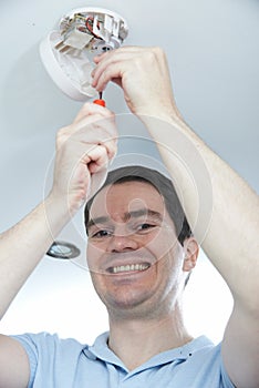 Man Installing Smoke Or Carbon Monoxide Detector