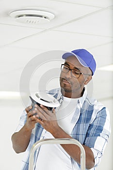 man installing smoke detector
