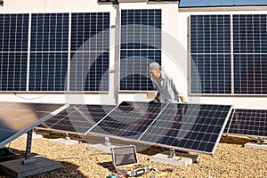 Man installing solar panels on the roof of his house