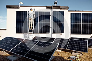Man installing solar panels on the roof of his house
