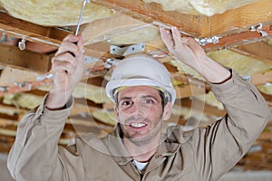 man installing thermal roof insulation layer