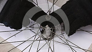 A man installs a bearing boot and an axle into the hub of the front wheel of a bicycle. Bike repair. Close-up
