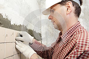 Man installs ceramic tile