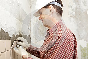 Man installs ceramic tile