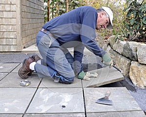 Man installs flagstone on patio