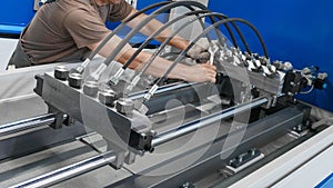A man installs high pressure hoses into a testing machine. Product quality control photo