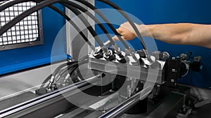 A man installs high pressure hoses into a testing machine. Product quality control photo