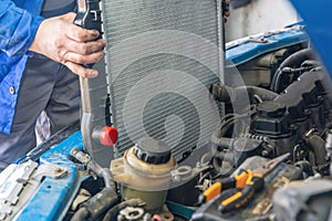 A man installs a new radiator in a car