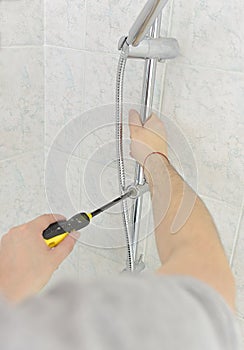 Man installs a new shower on the wall in the bathroom