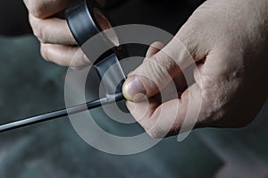 A man is insulating a black electrical wire