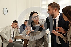 Man interrupting colleagues fight at work