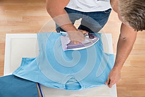 Man Ironing Clothes At Home