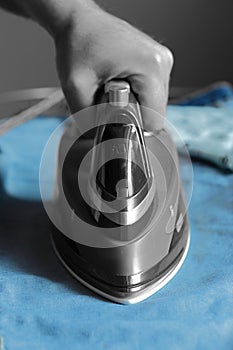 Man ironing jeans with an electric iron