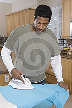 Man Ironing Shirt At Home