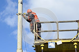 Man ironworker repairing trolleybus rigging standing on a truck mounted lift