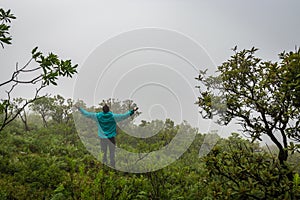 Man isolated feeling the serene nature at hill top with amazing cloud layers in foreground