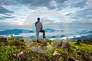 Man isolated watching the serene nature at hill top with amazing cloud layers in background