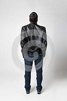 Man isolated on white background looks up and has his hands in the diestro pockets of his blue jeans photo