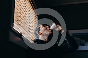 A man in isolation taking a pills from medicine bottle. Man forced to stay inside the house as a result of the restrictions caused