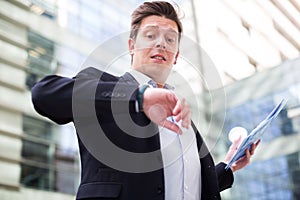 Man in jacket with documents hurrying to meeting