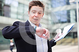 Man in jacket with documents hurrying to meeting