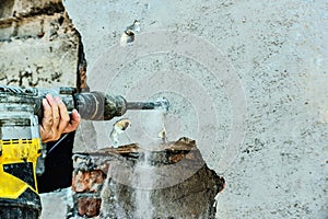 A man with a jackhammer makes an opening in the wall