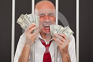 Man in jail crying and holding cash photo