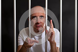 Man in jail gesturing guns with his hands