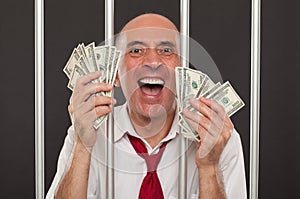 Man in jail laughing with cash