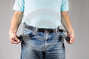 Man in jeans pulling out his empty pockets