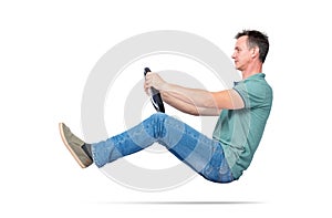 Man in jeans and t-shirt drives a car with a steering wheel, isolated on white background. Auto driver concept