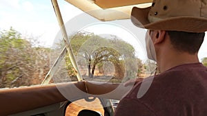 man on jeep driving trough african savannah, safari tour, green nature landscape, kenya, tsavo east