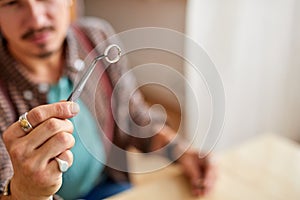 man jeweller examines polished ring, checking