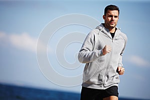 Man, jog and exercise on beach for fitness, workout and body health for physical training. Male runner or athlete and