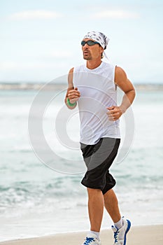 Man is jogging on the beach summertime sport fitness