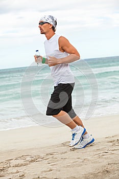 Man is jogging on the beach summertime sport fitness