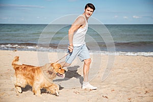 Man jogging and having fun with dog on the beach