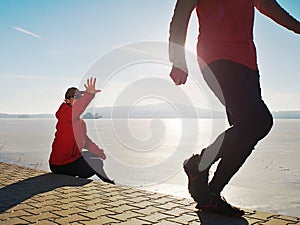 Man jogging at his girlfriend at river bank.  Hills with hot Sun