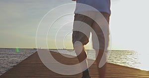 Man jogging on the pier at sunset